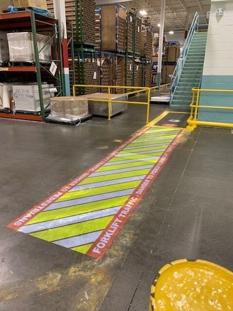 "Forklift traffic" warning sign projected onto the warehouse floor