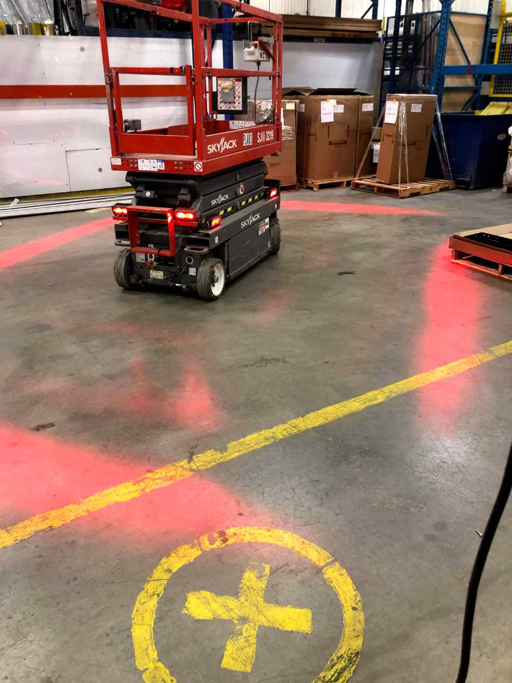 Bright red light projected by ForkCast around the forklift