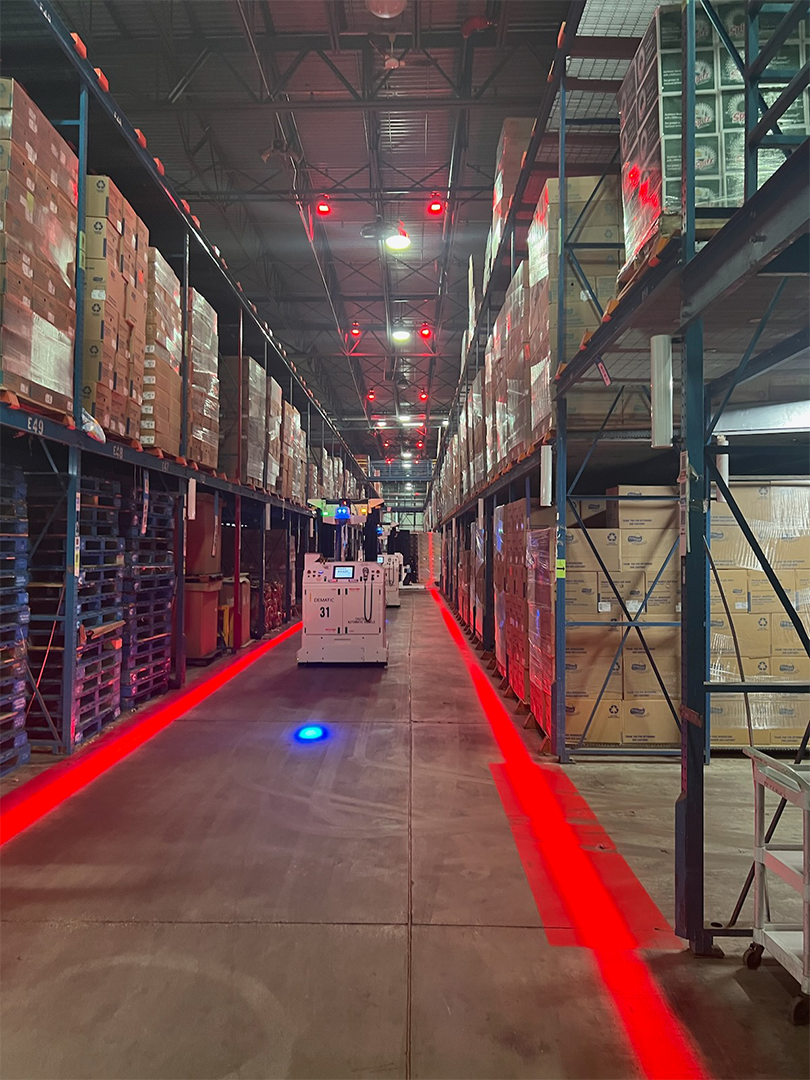 Forklift moving between the red safety lines projected onto the floor