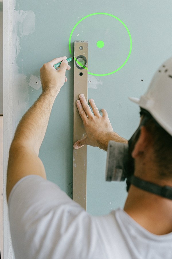A worker is measuring required wall length using Laserglow's Alignment Laser