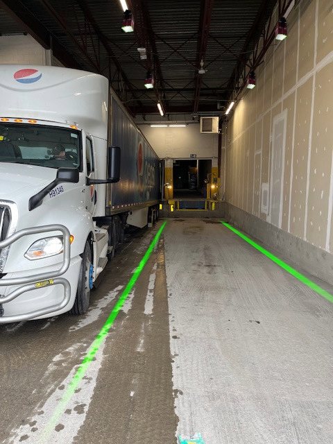 Bright green laser guides projected onto the floor to mark safe pedestrian path