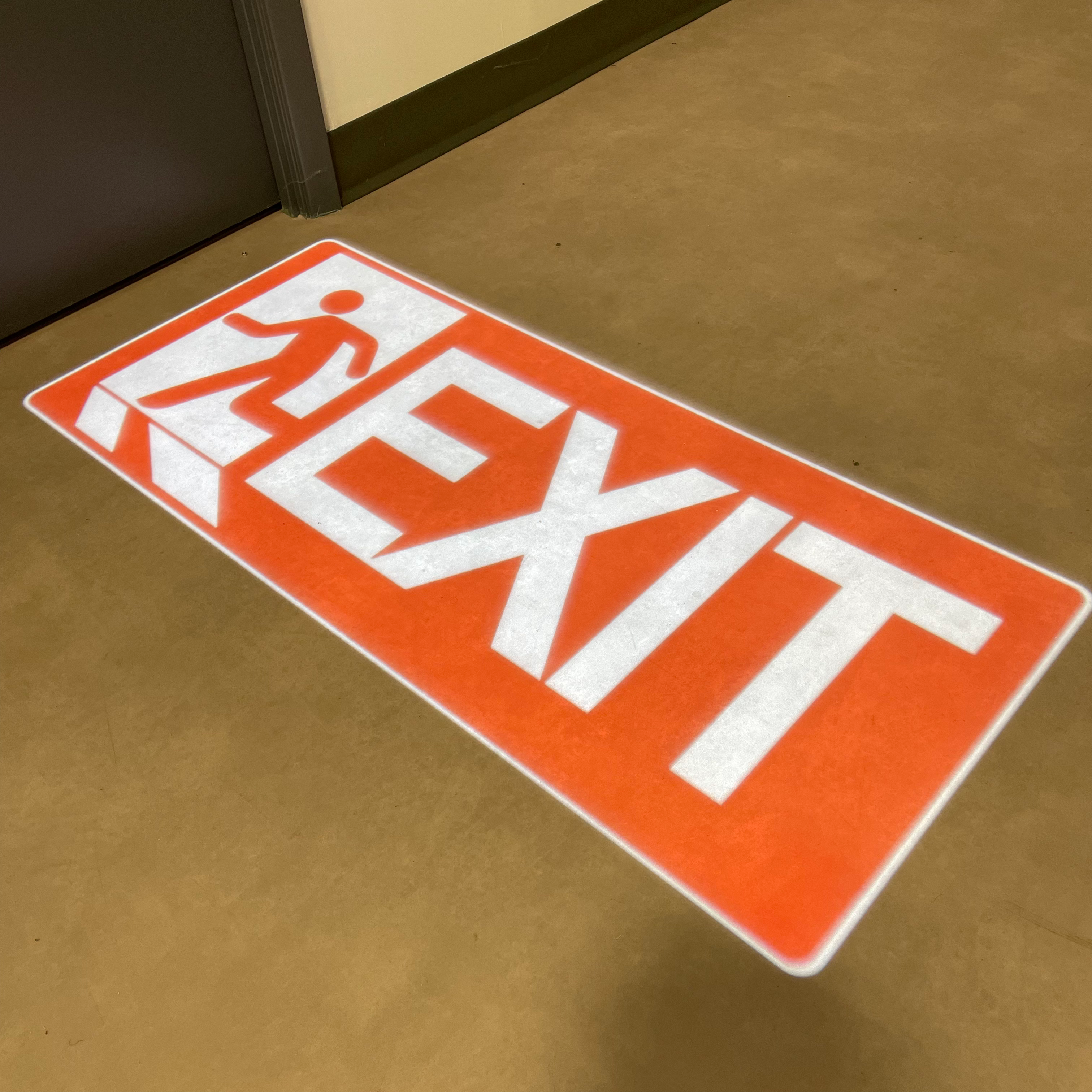 Large square "Exit" sign projected onto the floor for directional guidance